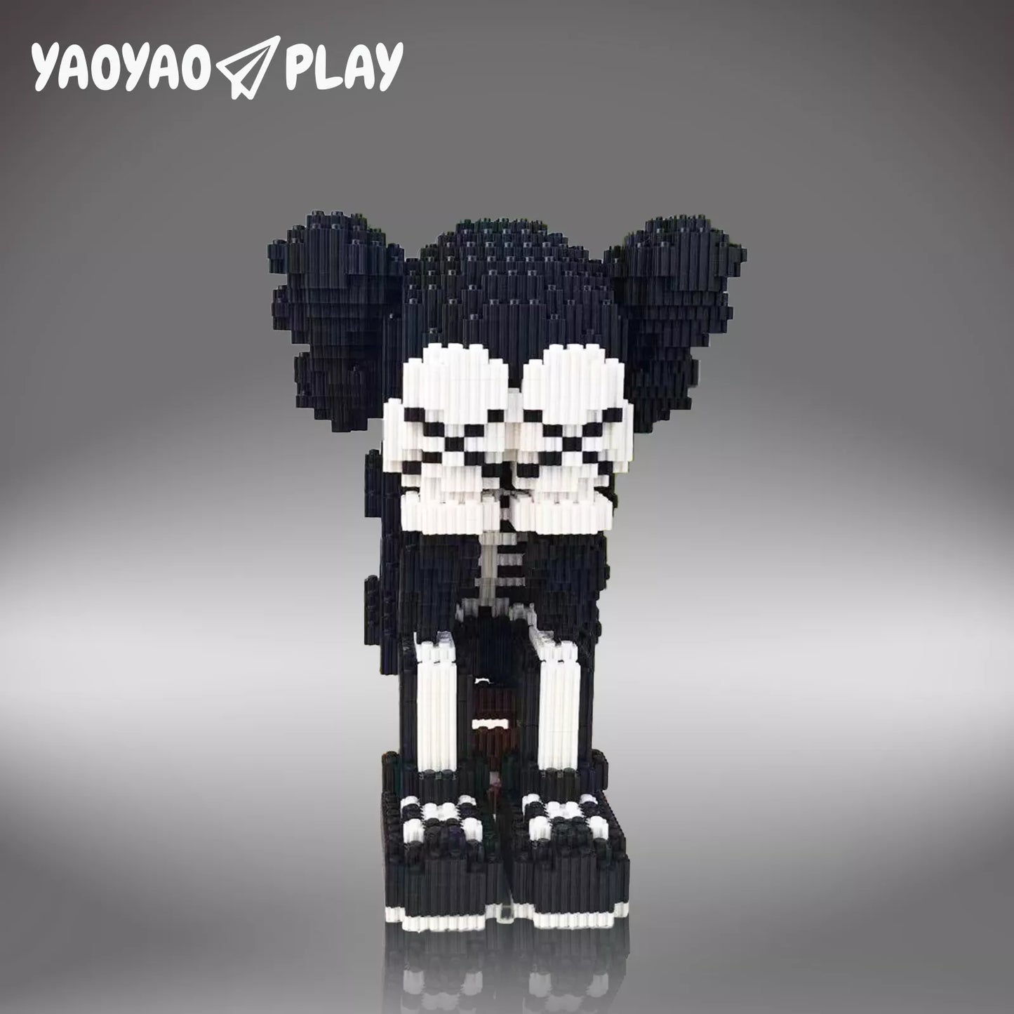 Pixel-art ​​Brick Bear toy​​ in black-and-white with precision joints on a neutral gray studio backdrop.